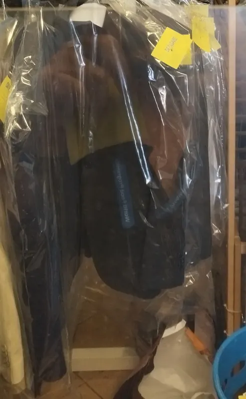 Capi lavati e imbustati, appesi con il cartellino giallo in attesa del ritiro
